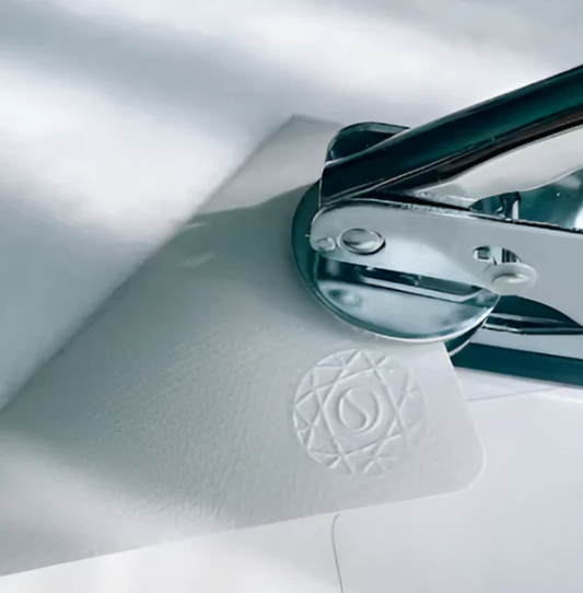 Custom paper embosser in action, imprinting personalized text on envelope flap