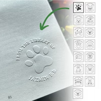 Close-up of dog book embosser pressing a paw and bone design
