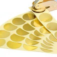 Gold foil embosser sticker with a crisp raised impression, displayed on a white background